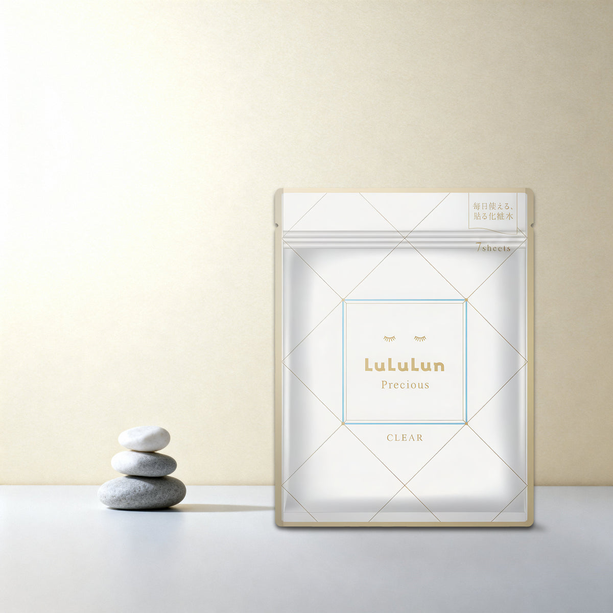 מסכת LuLuLun Precious CLEAR על משטח בהיר, לצד אבנים חלקות