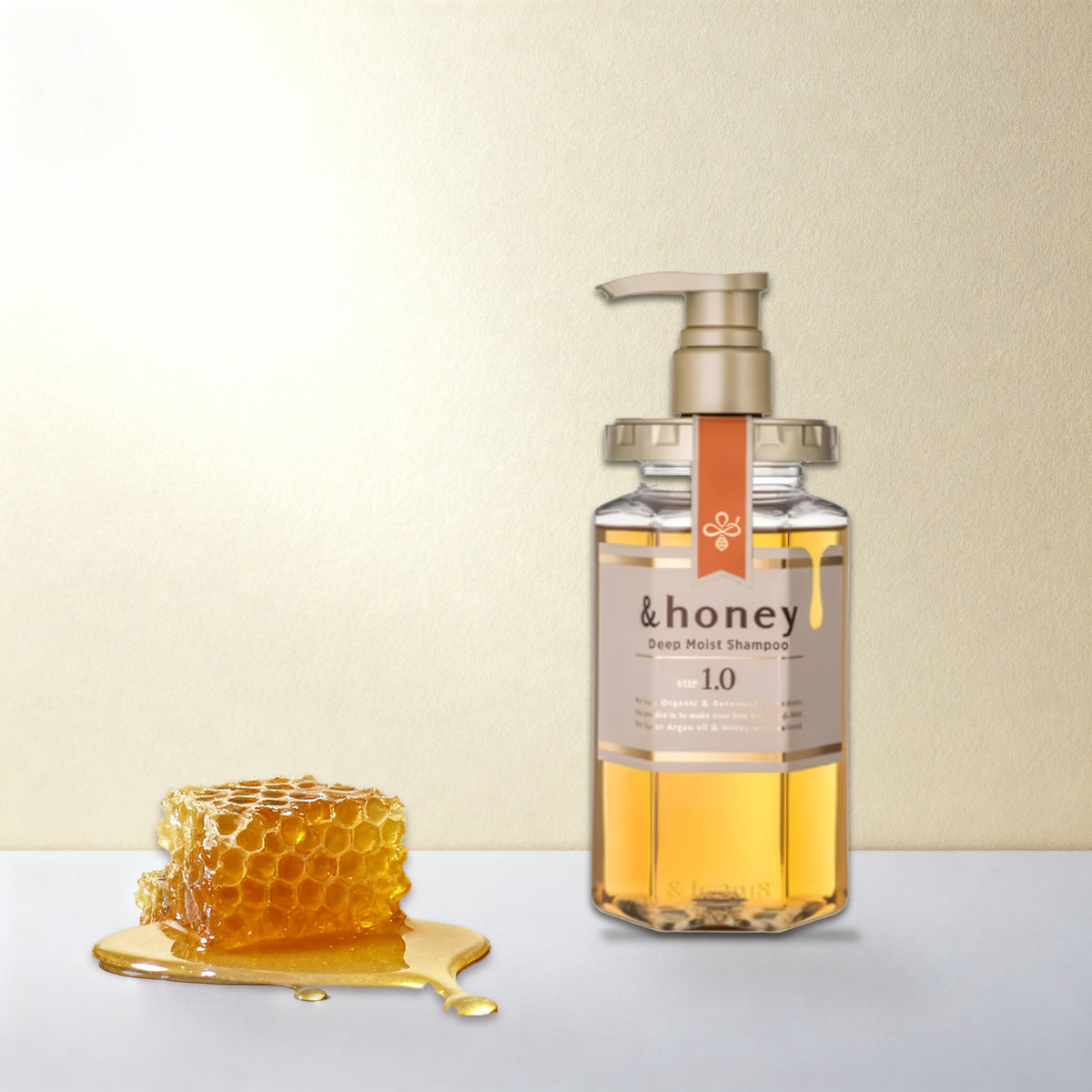 שמפו honey& 1.0 על משטח בהיר, לצד חלת דבש